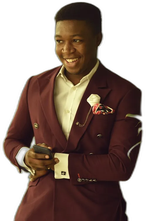 A young man in a suit smiling at his phone